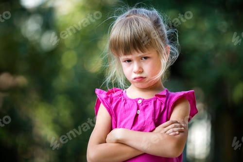 Preview: Portrait of pretty funny moody young blond child girl in pink sleeveless dress looks in camera