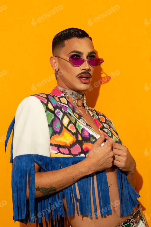 Preview: young drag queen in colorful dress on yellow background