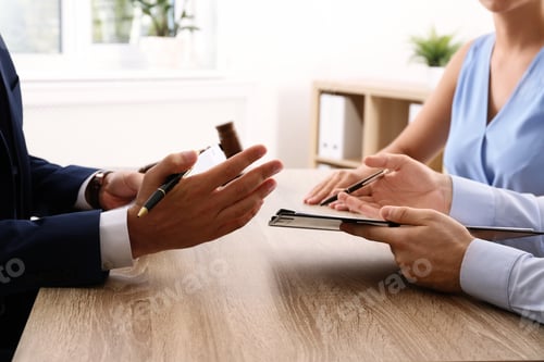 Preview: Lawyer working with clients at table in office, focus on hands