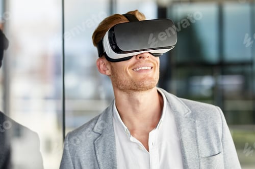 Preview: Smiling businessman wearing VR glasses