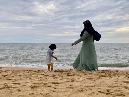 Preview: Mother and daughter standing enjoying the sandy beach
