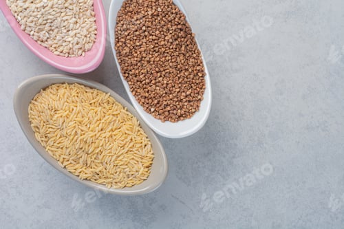 Preview: Three bowls with rice, wheat and buckwheat on marble background