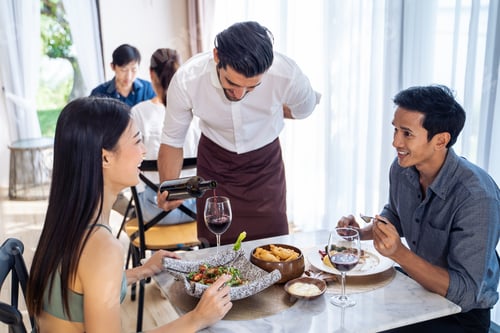 Preview: Caucasian waiter receiving order serving from customer in restaurant.