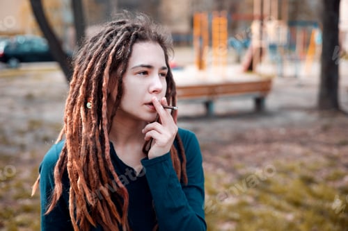 Preview: young pretty girl teenage with dreadlocks outside smoking cigarette, looking like real junky, social