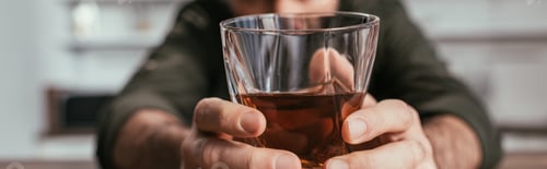Preview: Selective focus of man holding whiskey glass in hands, panoramic shot