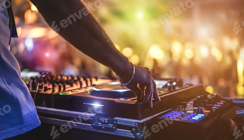 Preview: Dj mixing outdoor at beach party festival with crowd of people in background