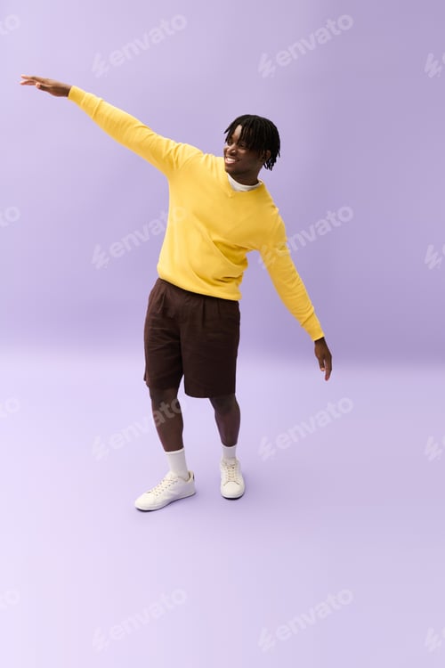 Preview: Stylish young man showcases vibrant fashion against a simple backdrop