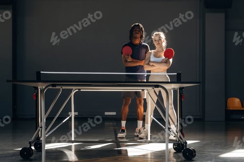 Preview: With arms crossed, standing together. Tennis game, man and woman are indoors