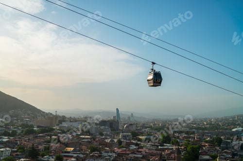 Preview: Beautiful shot of a cable car over buildings against blue sky
