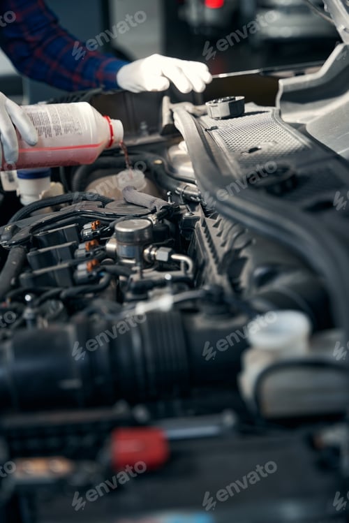 Preview: Close up photo of man pouring antifreeze