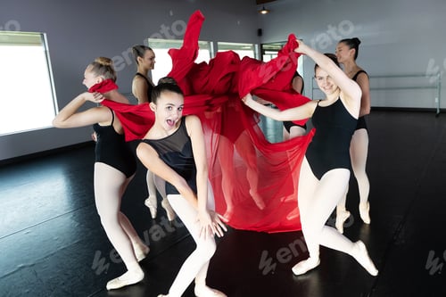 Preview: Group of young ballet dancers playing and having fun in dance studio with colorful fabric