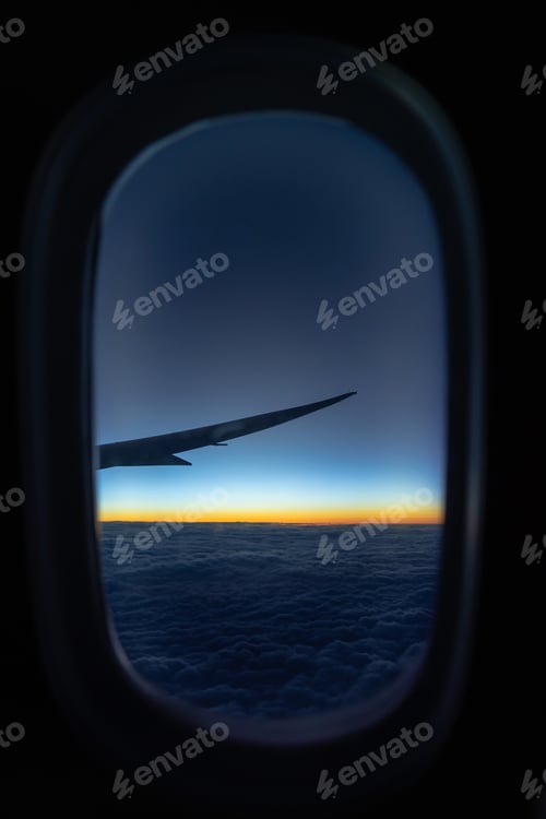 Preview: Scene of Airplane wing over the cloud and fantastic sky at sunrise time when flying above the land,