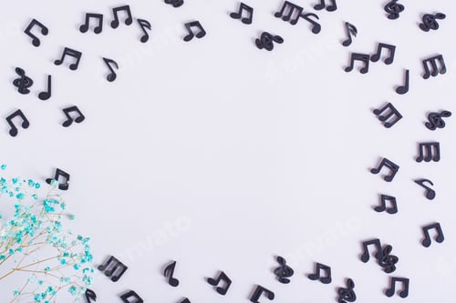 Preview: Musical concept frame made of black notes and dried flowers on a light background