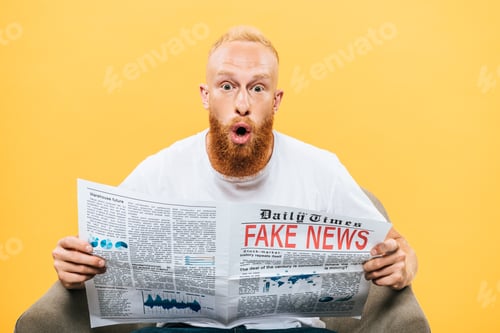Preview: surprised man reading newspaper with fake news while sitting on armchair, isolated on yellow