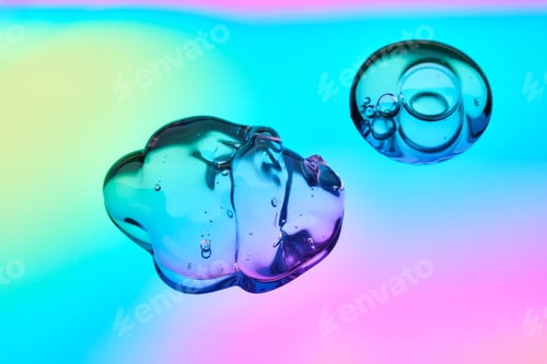 Preview: A drop of cosmetic serum on a multicolored background in shades of blue and lilac.