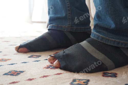 Preview: men feet with dirty socks while sitting on sofa