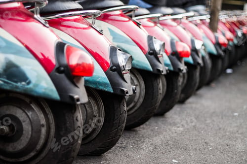 Preview: Closeup of row of red scooters parked in the street