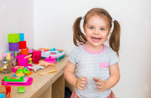 Preview: Happy Little Girl Smiles Surrounded by Toys