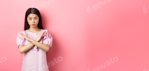 Preview: Serious chinese girl show cross sign, make stop gesture and look confident, block person, say no