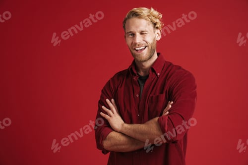 Preview: White bearded man smiling and winking while posing with arms crossed