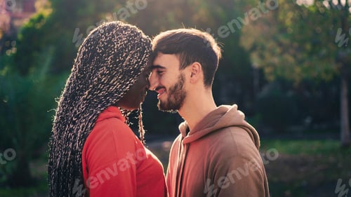 Preview: Romantic interracial couple touching foreheads at sunset