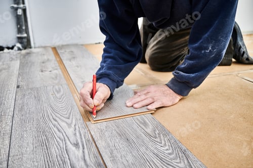 Preview: Male worker hands drawing line on laminate panel.