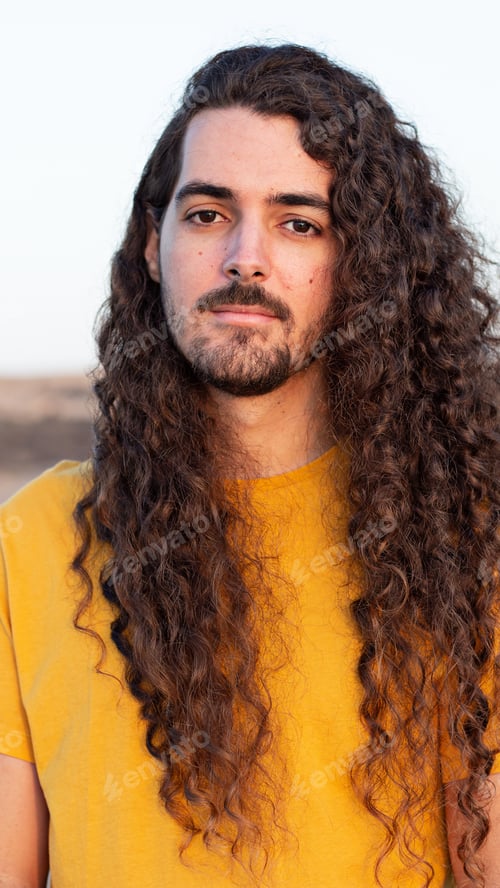 Preview: Vertical shot of a young man with long curly hair