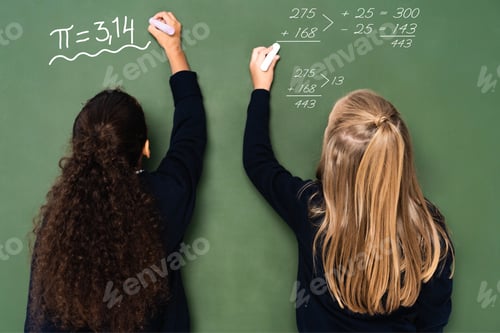 Preview: back view of multicultural schoolgirls writing mathematical equations on chalkboard