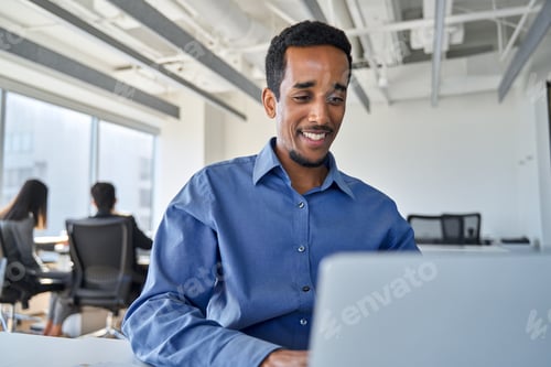 Preview: Busy African business man employee using laptop working in office.
