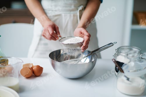 Preview: Anonymous Woman Sifting Flour into Mixing Bowl While Baking