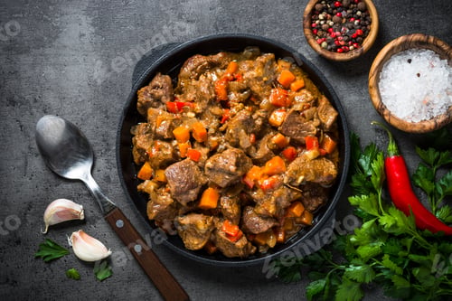 Preview: Beef stew with vegetables in iron pan on black