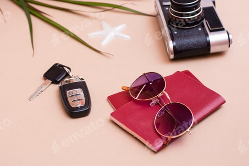 Preview: Bright travel flat lay with sunglasses, passports, vintage camera and car keys on a beige background