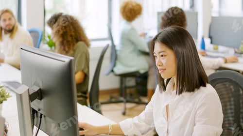 Preview: Asian woman working happily in a coworking space