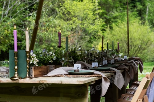 Preview: Dining table with candles and rustic place settings for a woodland naming ceremony.
