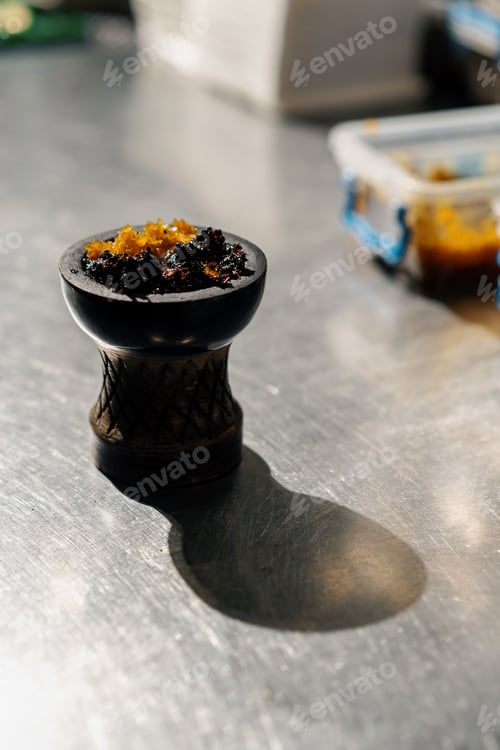 Preview: close-up of fragrant juicy yellow tobacco in hookah bowl Hookah preparation in lounge bar