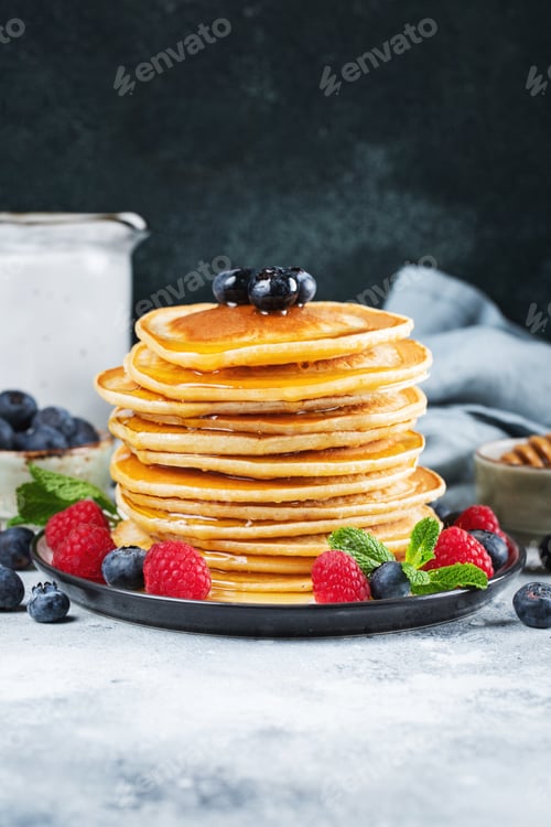 Preview: Delicious pancakes, with fresh blueberries, raspberry and maple syrup or honey on a dark background