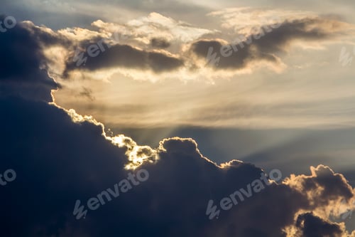 Preview: Panorama of sky at sunrise or sunset. Beautiful view of dark blue clouds lit by bright orange yellow