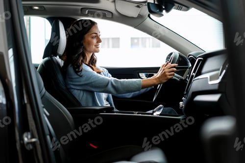 Preview: Woman driving modern car and smiling, enjoying road trip