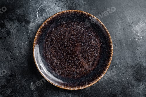 Preview: Empty black craft plate on table. Table setting. Black background. Top view. Copy space