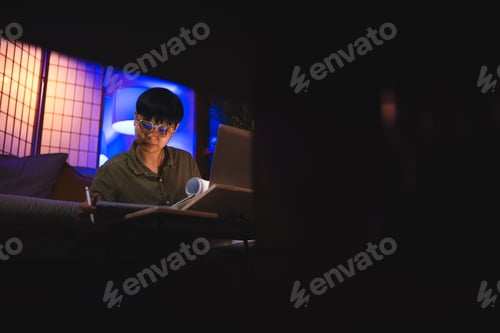Preview: Late-night freelancer, Dedicated Asian woman working overtime on laptop computer, meeting deadlines