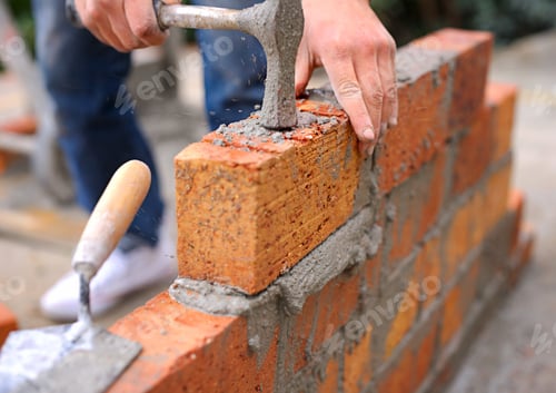 Preview: Laying the foundation one brick at a time. Shot of a master bricklayer at work.