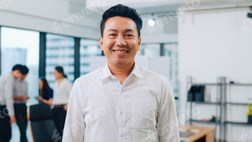 Preview: Portrait of successful executive businessman looking at camera and smiling in office.