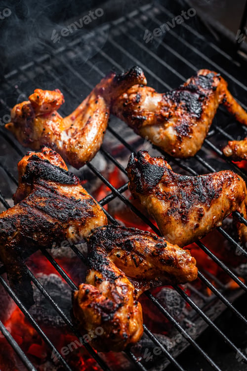 Preview: Chicken wings on barbecue, outdoor BBQ grill with fire. Top view