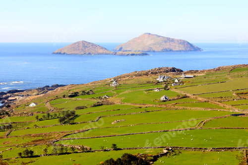 Preview: View looking down on green pastures and ocean with islands in distance ok a beautiful day