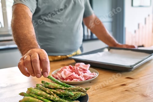 Preview: Man's hand taking asparagus from plate.