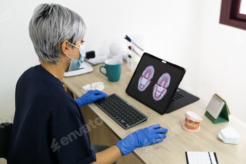 Preview: Shallow focus of a female dental technician designing a new dental prosthesis in a clinic