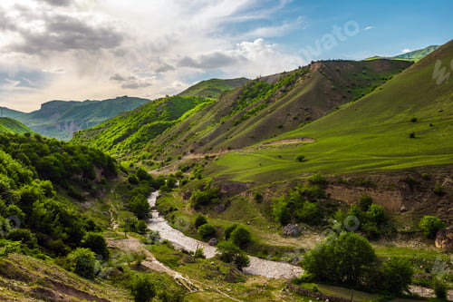 Preview: River bed between green mountains