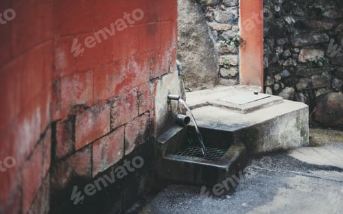 Preview: Old water spout in red brick wall