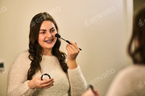 Preview: Young Woman Applying Blush Smiling In Front Of Mirror