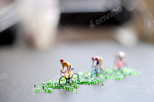 Preview: Miniature Cyclists Racing on a Road of Green Beads — Creative Concept of Sport